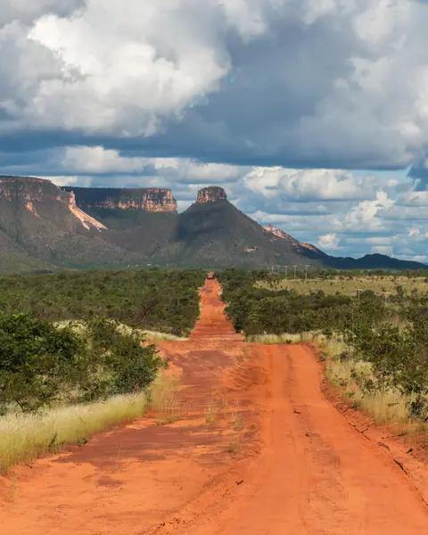 Estrada de terra vermelha rumo à serra no Jalapão